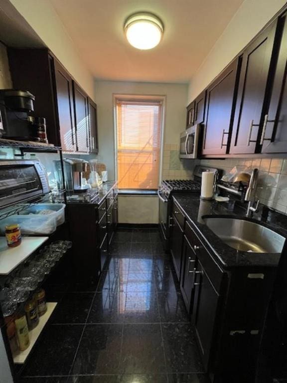 kitchen with dark brown cabinetry, sink, black gas range oven, tasteful backsplash, and dark tile patterned flooring