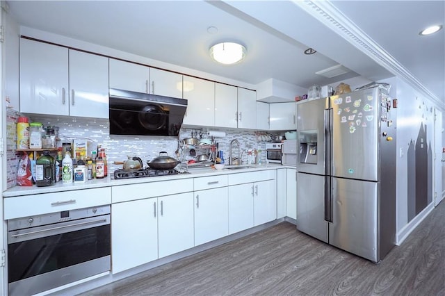 kitchen featuring sink, tasteful backsplash, dark hardwood / wood-style flooring, stainless steel appliances, and white cabinets