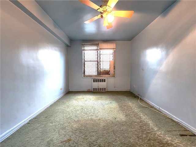 unfurnished room featuring carpet floors, radiator heating unit, baseboards, and ceiling fan