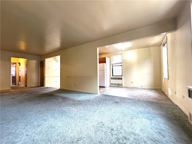 empty room featuring carpet and baseboards