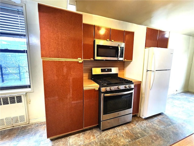 kitchen with appliances with stainless steel finishes and radiator heating unit