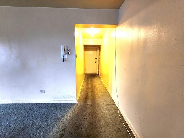 hallway featuring dark carpet