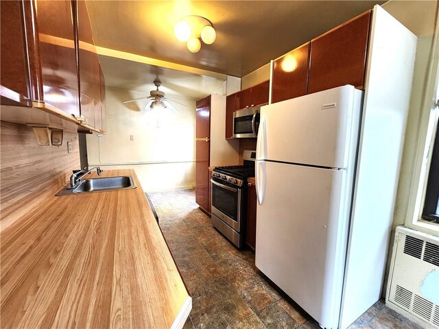 kitchen with sink, backsplash, ceiling fan, and appliances with stainless steel finishes