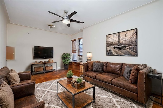 living room with ceiling fan and baseboards