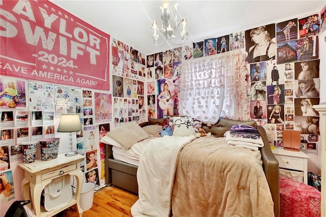 bedroom with a notable chandelier and light wood-type flooring