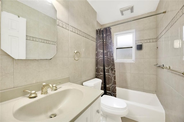 full bathroom featuring toilet, vanity, tile walls, and shower / tub combo with curtain