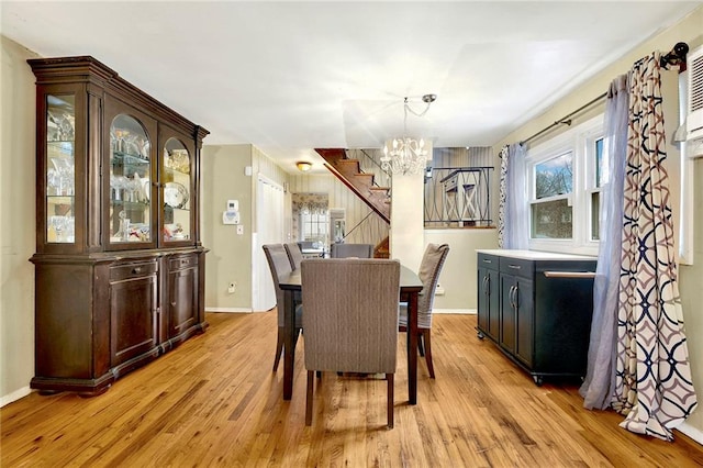 dining area featuring light wood-type flooring and a notable chandelier