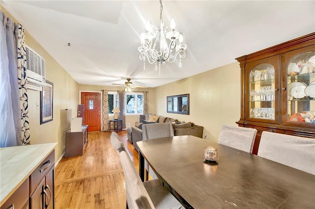 dining area with ceiling fan with notable chandelier and light hardwood / wood-style flooring