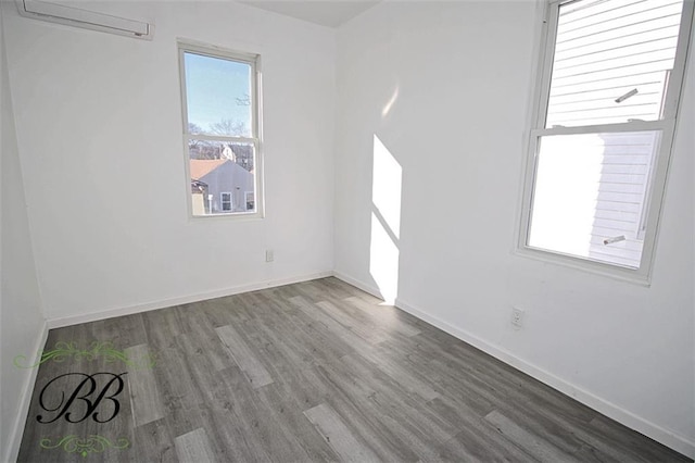 empty room featuring wood-type flooring and an AC wall unit