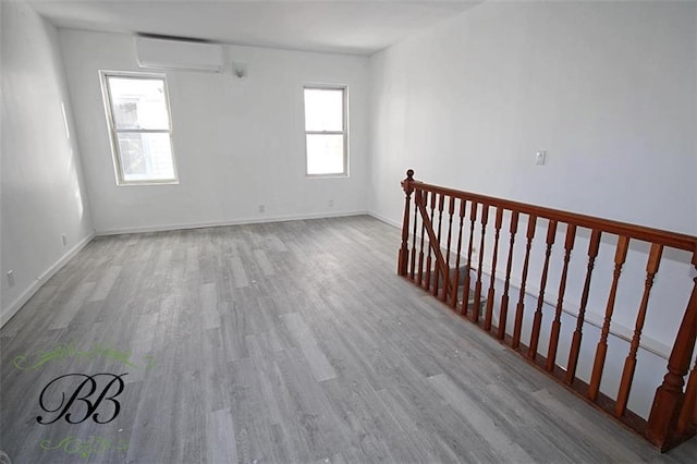 spare room with hardwood / wood-style flooring and a wall unit AC