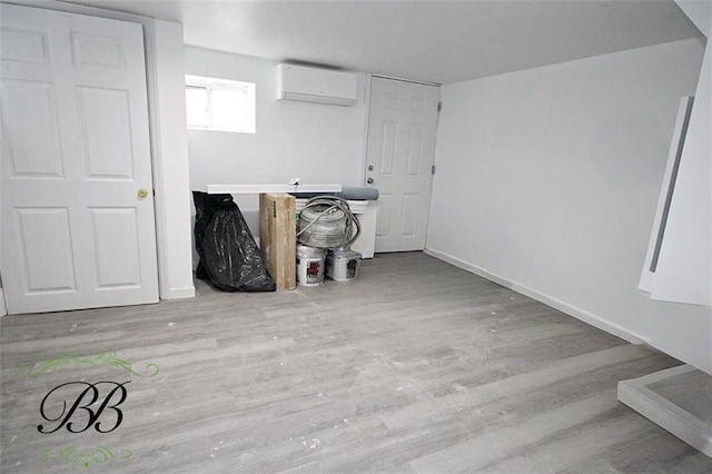 interior space with light hardwood / wood-style floors and an AC wall unit