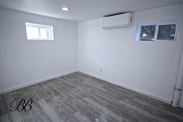 basement with dark hardwood / wood-style flooring and a wall unit AC