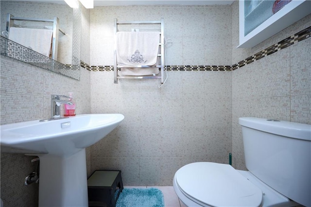 bathroom with toilet and tile walls