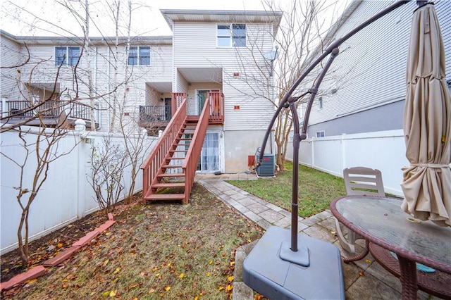 back of house with cooling unit and a yard