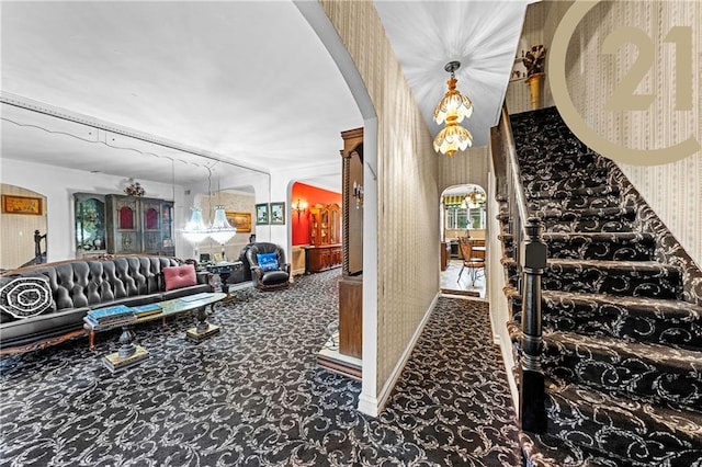 staircase featuring arched walkways, carpet floors, and wallpapered walls