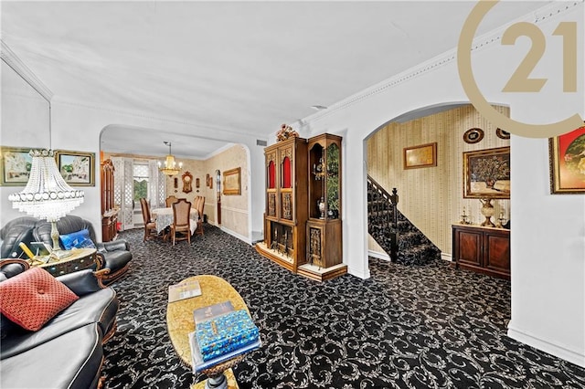 living room featuring arched walkways, carpet, a notable chandelier, stairway, and ornamental molding