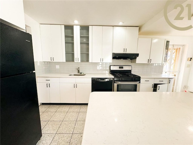 kitchen with light countertops, glass insert cabinets, a sink, under cabinet range hood, and black appliances