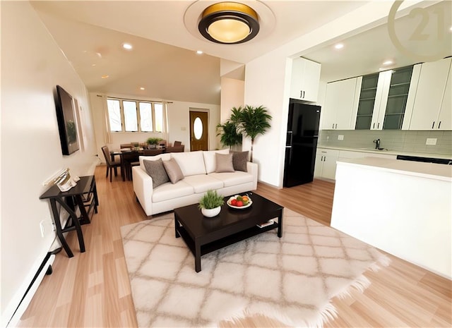 living area featuring recessed lighting, vaulted ceiling, and light wood-style flooring