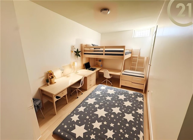 bedroom featuring built in study area and light wood-style flooring