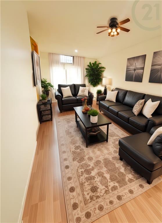 living area with ceiling fan, light wood-style flooring, and baseboards