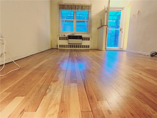 interior space with hardwood / wood-style floors and radiator heating unit