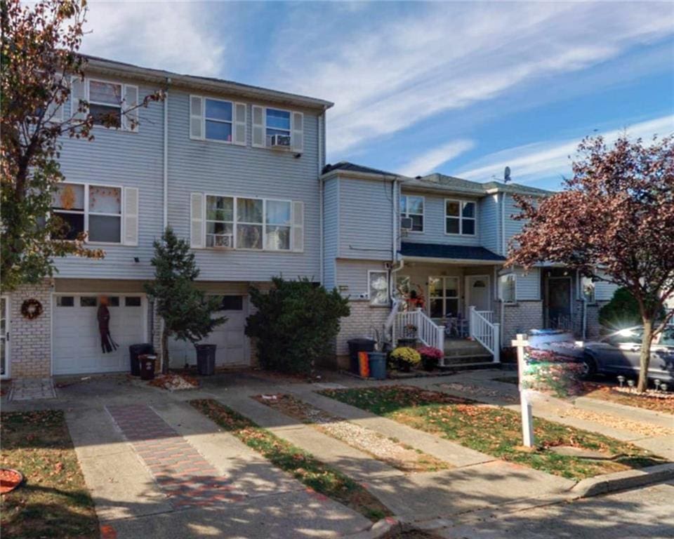 117 Lorraine Loop, Staten Island, NY 10309 - multi unit property with brick siding, an attached garage, driveway, and a porch