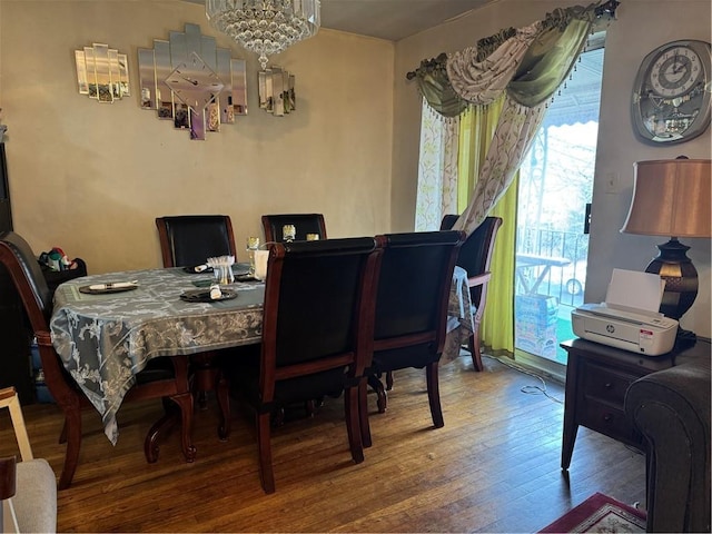 dining room with a notable chandelier and wood-type flooring