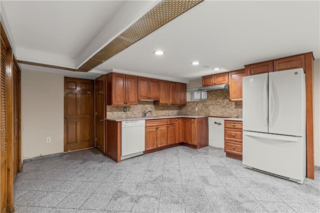 kitchen with tasteful backsplash, white appliances, and sink