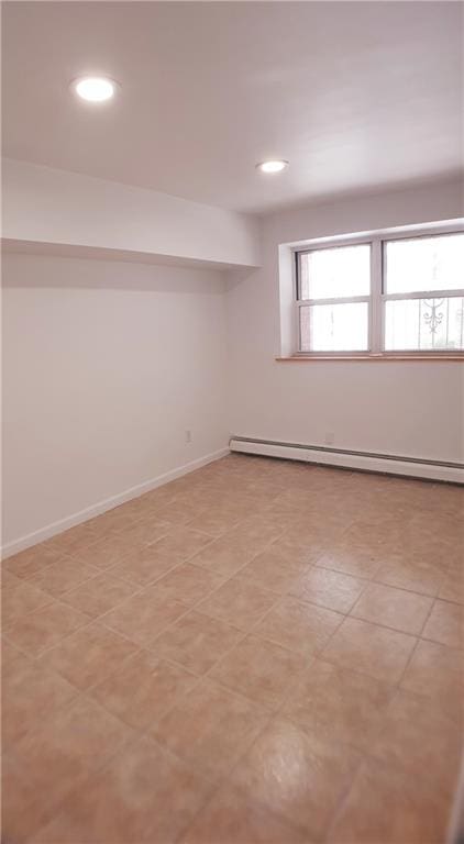 basement with light tile patterned floors and a baseboard heating unit