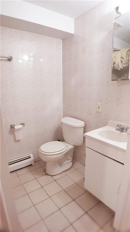 bathroom with tile patterned floors, vanity, a baseboard radiator, tile walls, and toilet