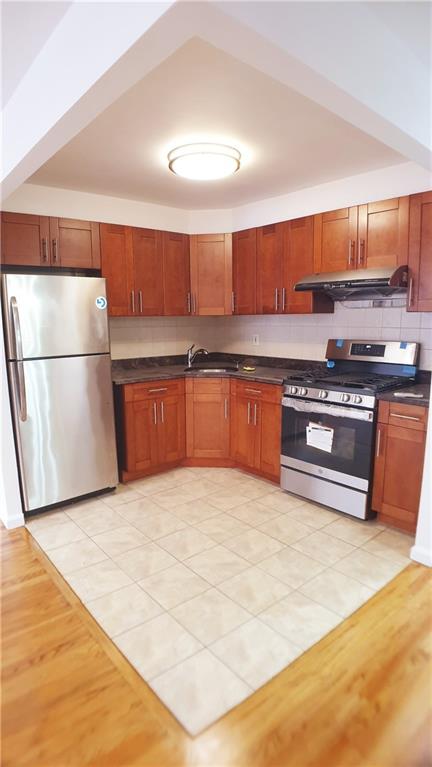 kitchen with decorative backsplash, light tile patterned flooring, sink, and stainless steel appliances