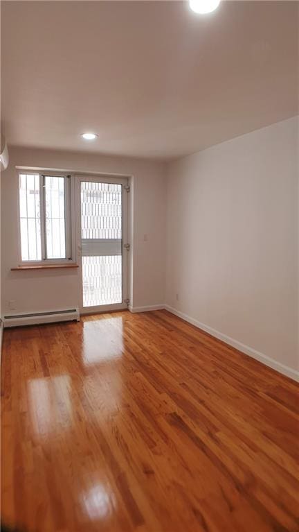 empty room featuring light hardwood / wood-style floors and baseboard heating