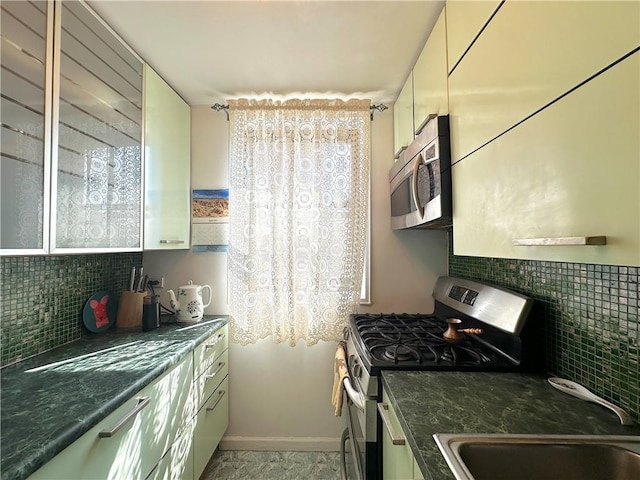 kitchen featuring stainless steel appliances, decorative backsplash, and plenty of natural light