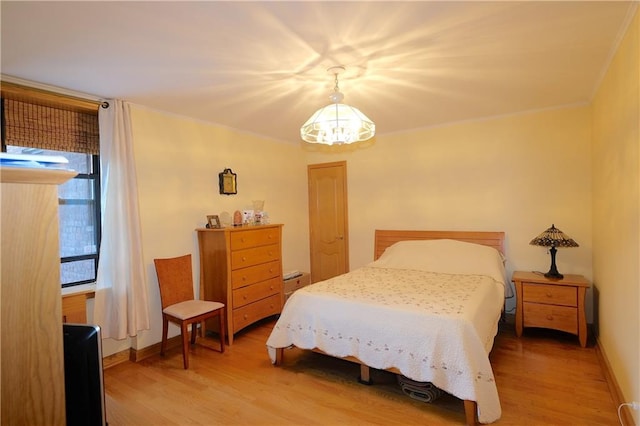 bedroom with hardwood / wood-style flooring and a notable chandelier