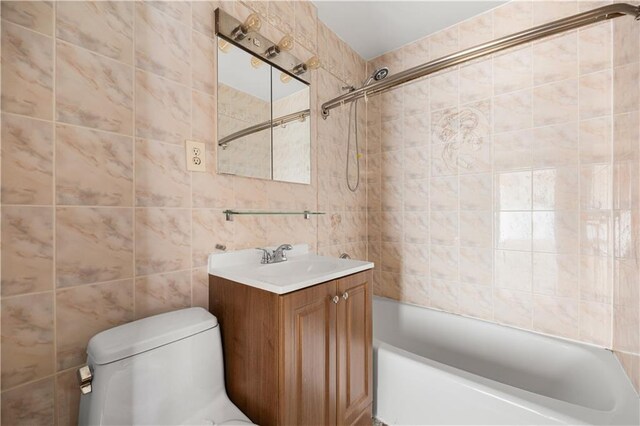 full bathroom featuring vanity, toilet, tile walls, and tiled shower / bath combo