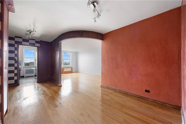 spare room with light wood-type flooring and radiator heating unit