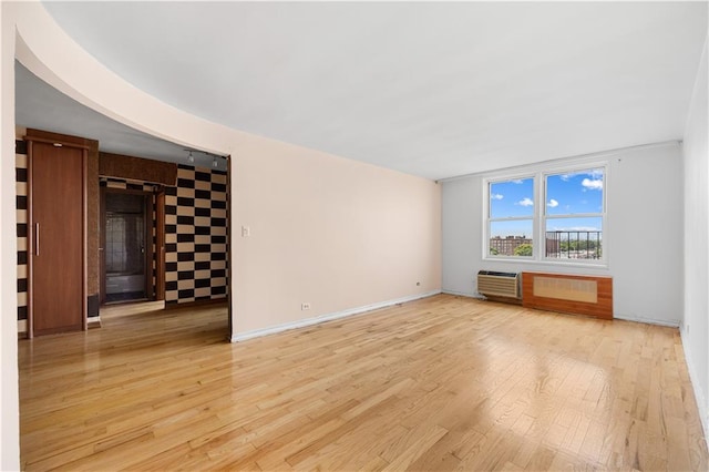 unfurnished living room featuring light hardwood / wood-style flooring and a wall mounted air conditioner