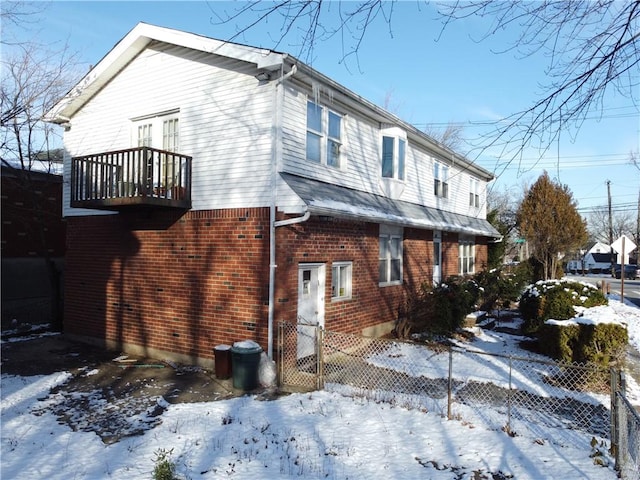 view of snow covered exterior with a balcony