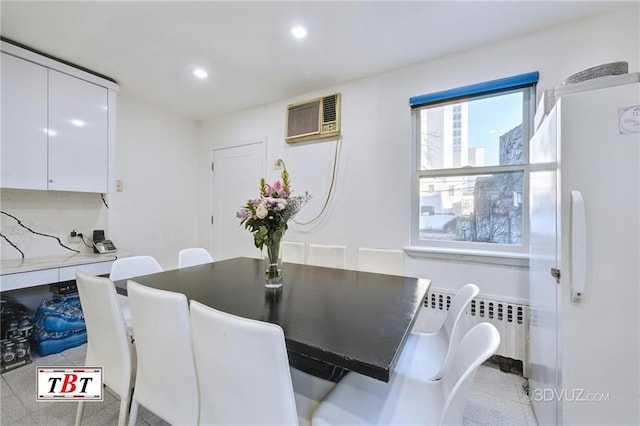 dining space featuring a wall mounted air conditioner and radiator