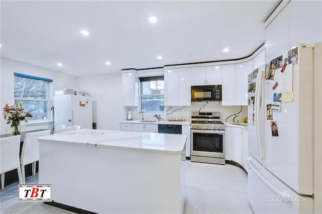 1801 E 7th St, Brooklyn, NY 11223 - kitchen featuring freestanding refrigerator, black microwave, stainless steel range with gas cooktop, white cabinetry, and recessed lighting