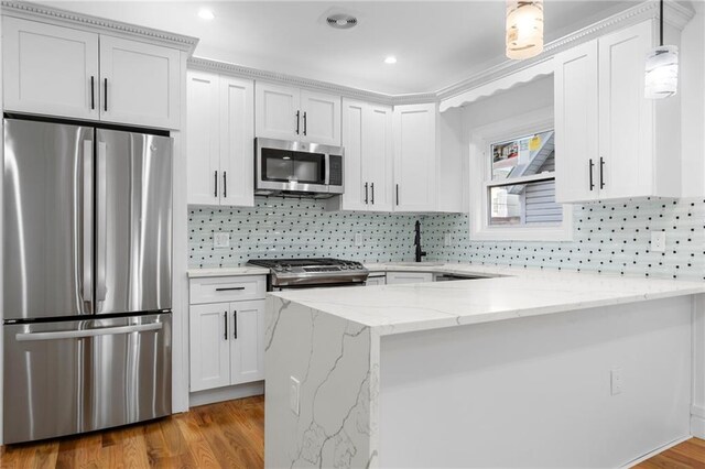 kitchen with sink, light wood-type flooring, appliances with stainless steel finishes, white cabinets, and light stone counters