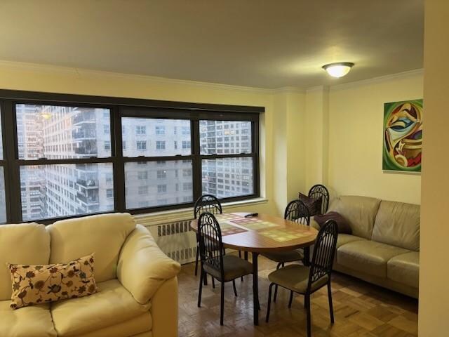 dining space with crown molding, parquet flooring, and a wealth of natural light