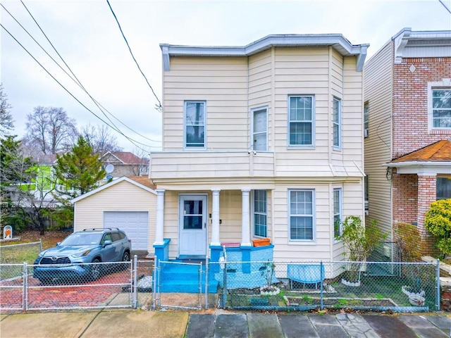 view of front of house with a detached garage, a fenced front yard, a porch, driveway, and a gate