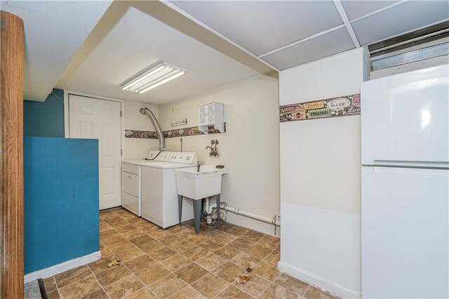 clothes washing area with washer and clothes dryer and sink