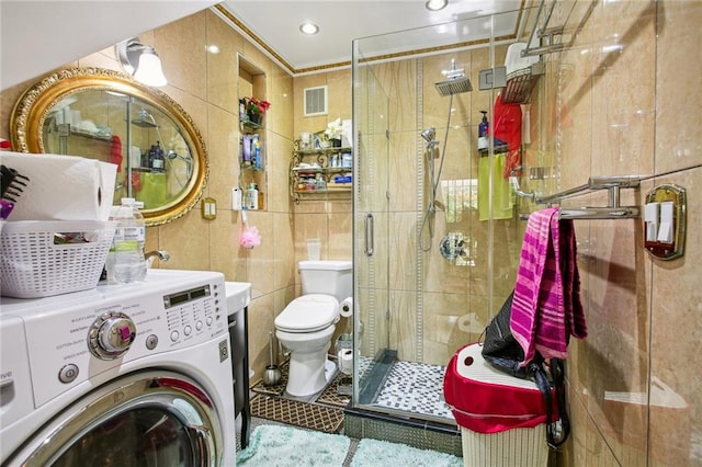 bathroom with an enclosed shower, toilet, tile walls, and washer / clothes dryer