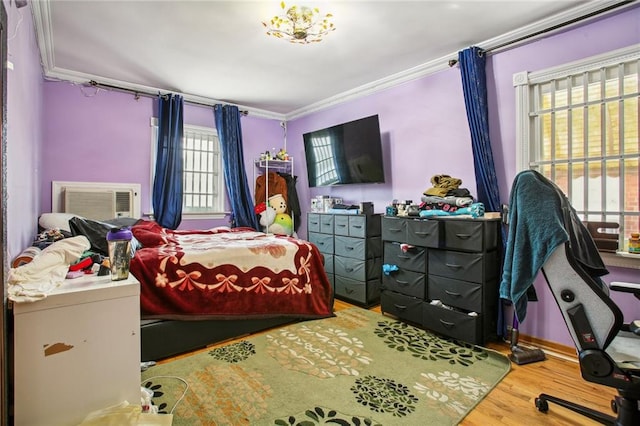 bedroom featuring wood-type flooring, crown molding, and multiple windows