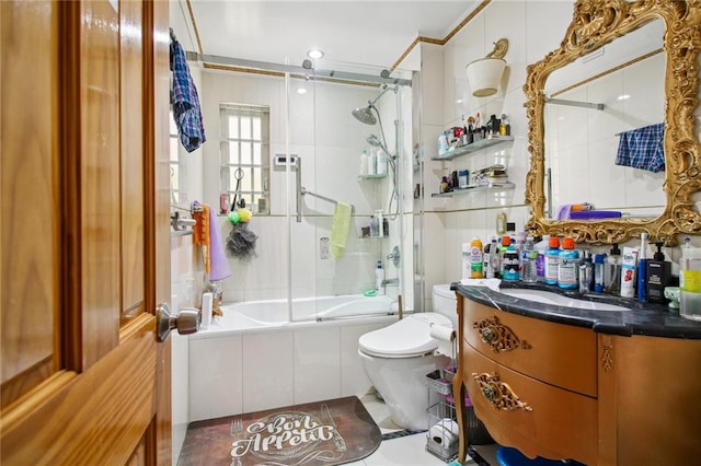 full bathroom featuring vanity, toilet, and combined bath / shower with glass door