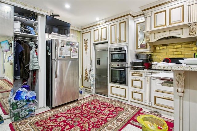 kitchen with light stone countertops, cream cabinets, and stainless steel appliances