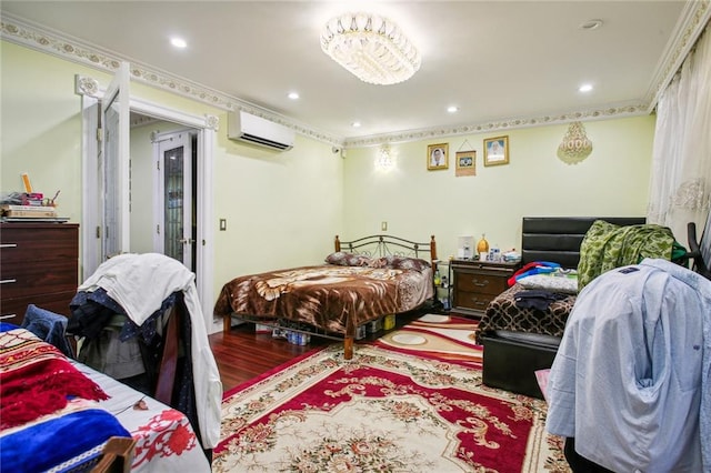 bedroom with hardwood / wood-style flooring, a wall unit AC, and crown molding