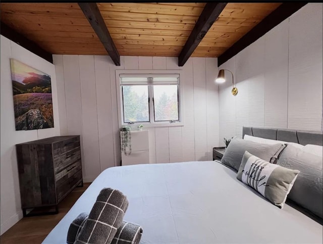 bedroom with beam ceiling, wood walls, and wooden ceiling